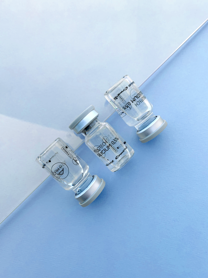 services-03 A minimalist top view of transparent medical vials on a light blue surface. Perfect for healthcare content.