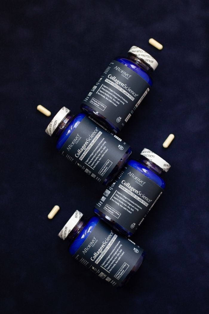 about-us AltNeve collagen supplements arranged artfully on a navy blue surface with capsules.