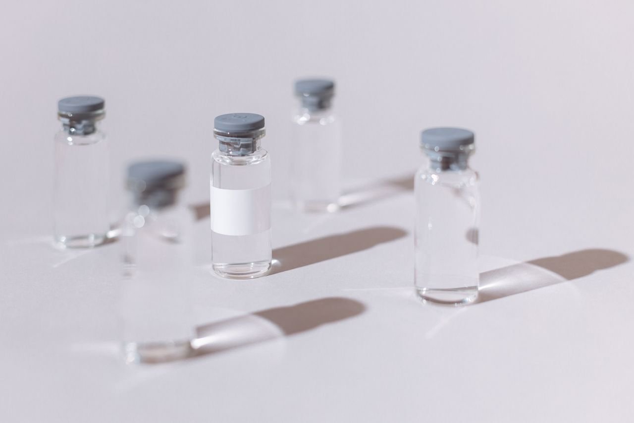 services-01 Clear glass vials used for vaccines or medication, displayed on a sterile white surface.