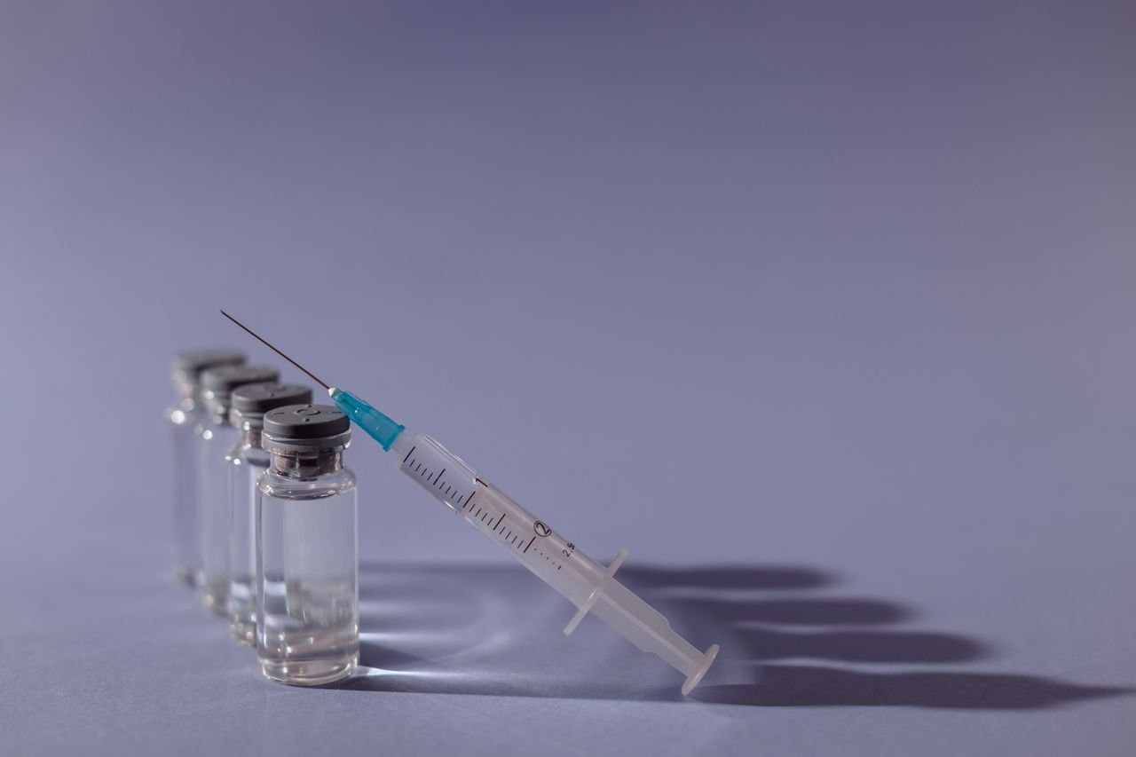 services-04 Syringe and vaccine vials arranged on gray surface, symbolizing healthcare and immunization.